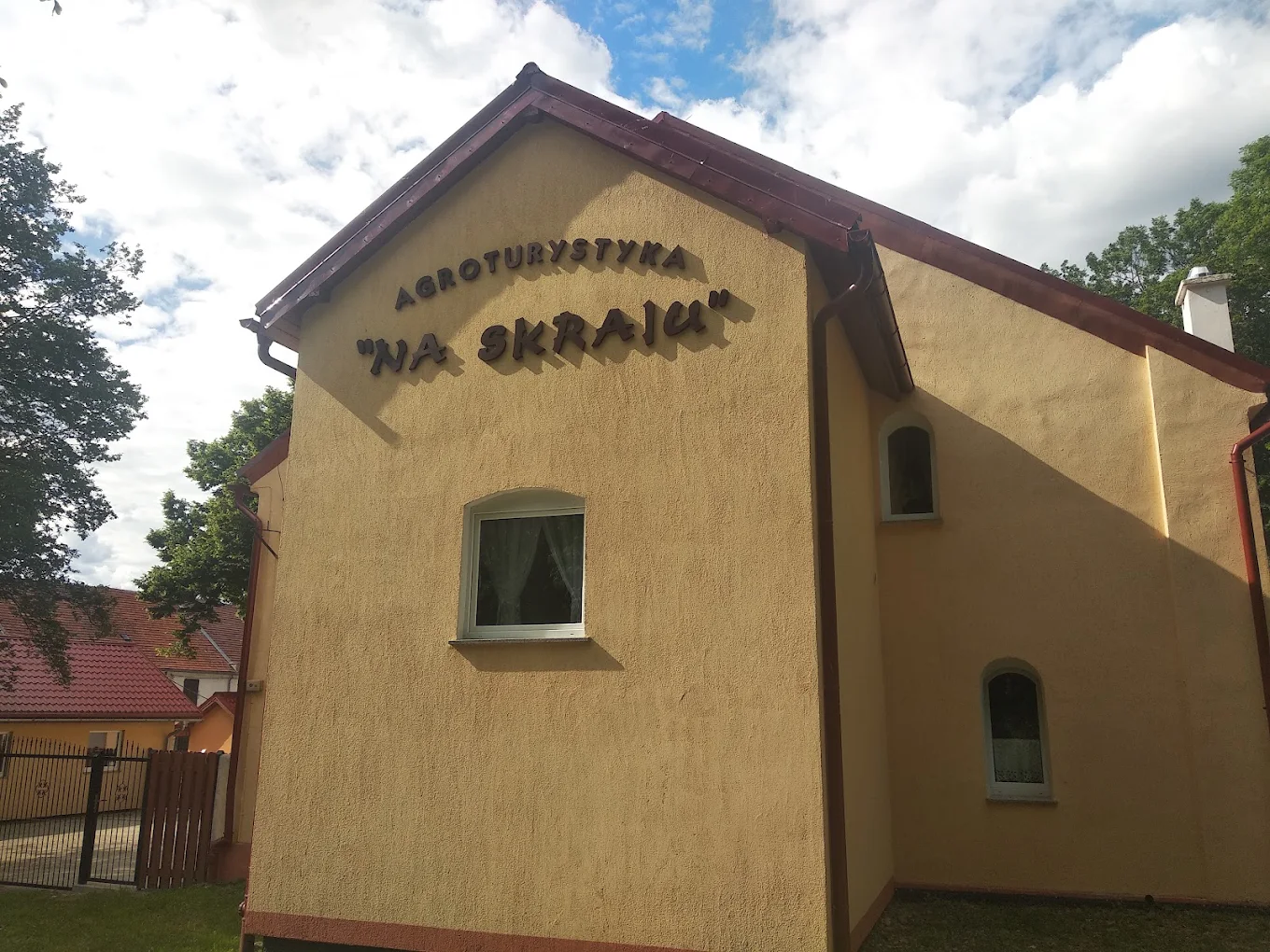 Szyld Agroturystyka Na Skraju na ścianie budynku
